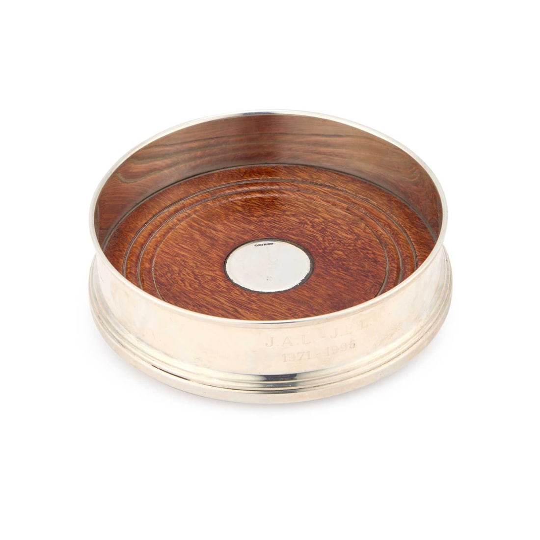 AN ELIZABETH II SILVER WINE COASTER: AN ELIZABETH II SILVER WINE COASTER by W.I. Broadway & Co, Birmingham 1997, in George III style, of circular form with a turned wooden base centred by a silver roundel. 12.5cm diameter