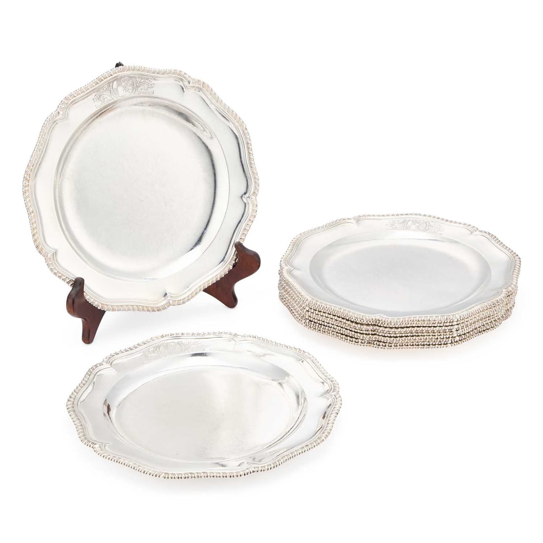 A FINE SET OF TWELVE GEORGE III SILVER DINNER PLATES: A FINE SET OF TWELVE GEORGE III SILVER DINNER PLATES by Augustin Le Sage, London 1768, of shaped circular form with a gadrooned edge, engraved with arms and motto. (12) 24cm diameter, 174.5 troy ounce
