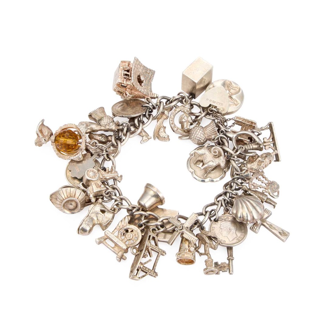 A SILVER CHARM BRACELET: A SILVER CHARM BRACELET with a heart padlock closure, the chain adorned with various charms including a horse, imp on a horse shoe, enamel four leaf clover, Ankh, bagpipes, etc. 105.8 grams