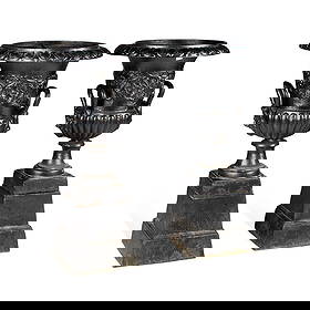 A PAIR OF CAST IRON URNS ON STANDS: A PAIR OF CAST IRON URNS ON STANDS of two-handled campana form, cast with scrolling foliage. (2) 86cm high