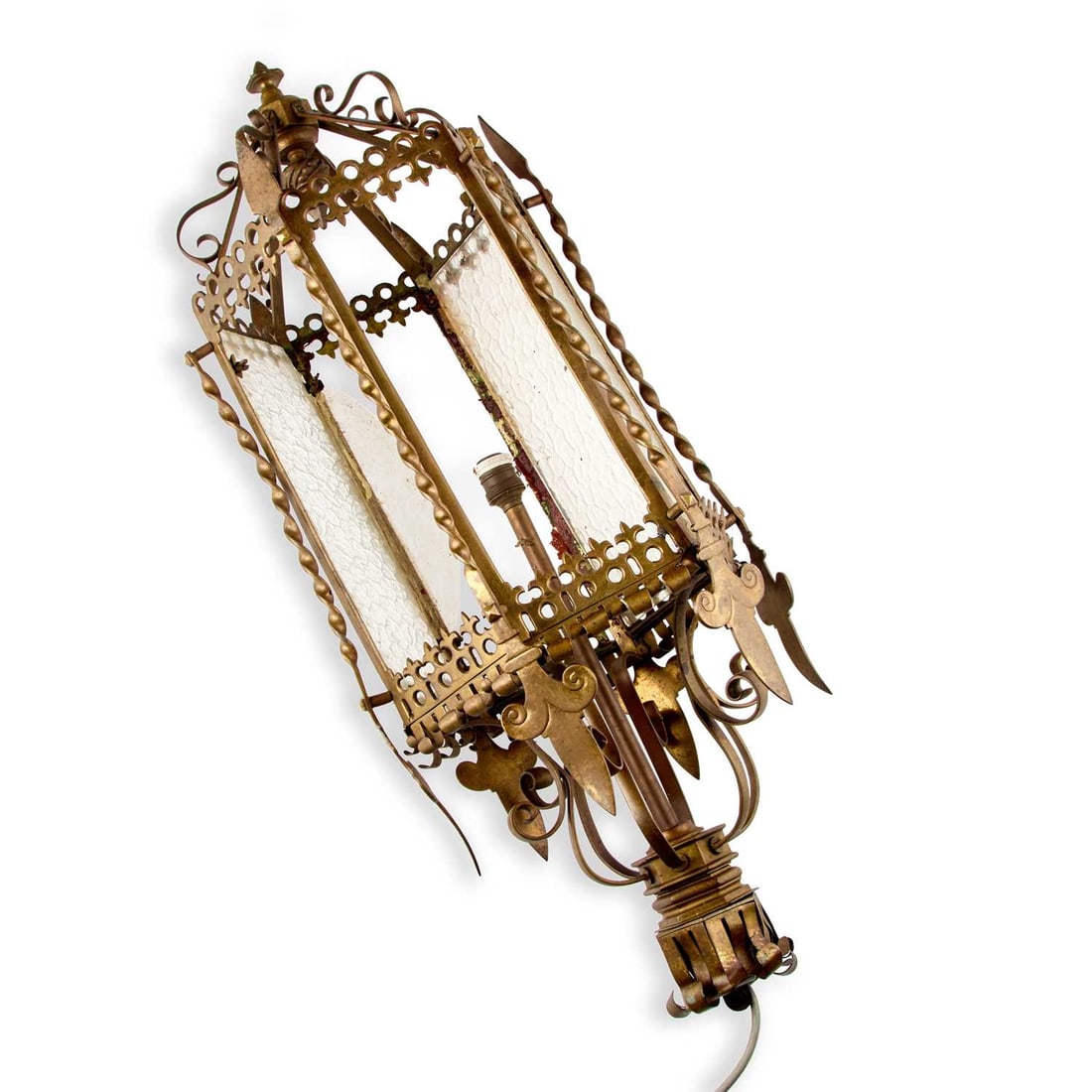 A LATE VICTORIAN WROUGHT AND CAST BRASS HANGING LANTERN: A LATE VICTORIAN WROUGHT AND CAST BRASS HANGING LANTERN of hexagonal form with textured glass panels framed by twist uprights, the pierced and scrolling cresting with leaf finials above a conforming b