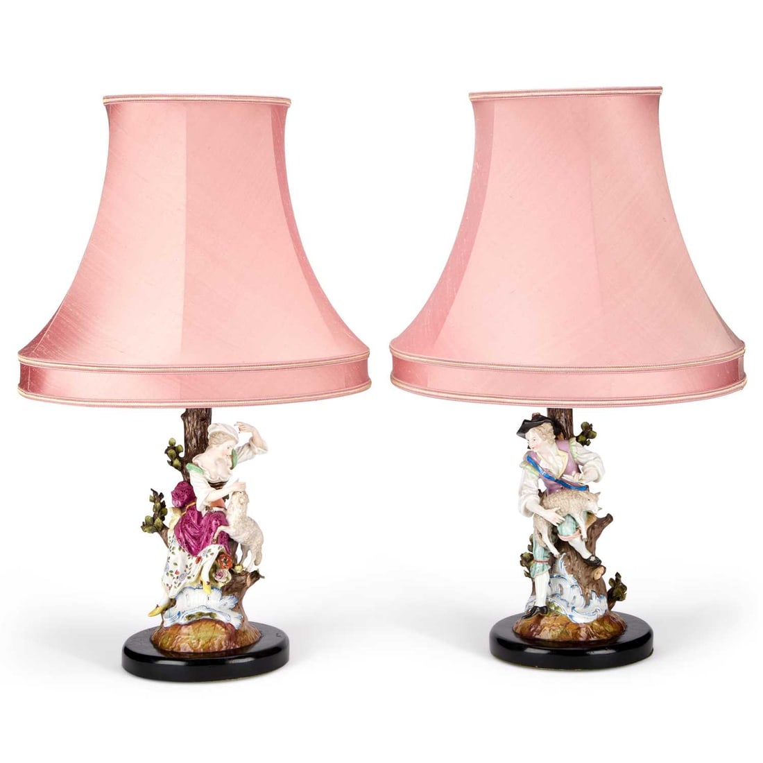 A PAIR OF CONTINENTAL PORCELAIN FIGURAL TABLE LAMPS: A PAIR OF CONTINENTAL PORCELAIN FIGURAL TABLE LAMPS modelled as a shepherd and shepherdess seated beside tree stumps with their lambs, each figure finely hand-painted in bright enamel colours with gil