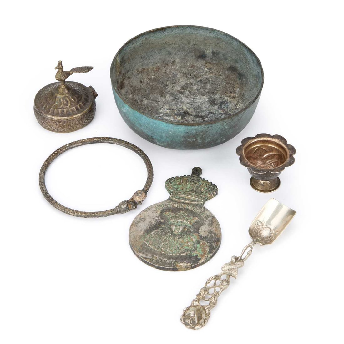 A GROUP OF CONTINENTAL AND EASTERN METALWARE: A GROUP OF CONTINENTAL AND EASTERN METALWARE comprising a small copper or bronze bowl of rounded form, a miniature silver or white-metal goblet with a petal rim, a bangle, a cast medallion stamped Sto