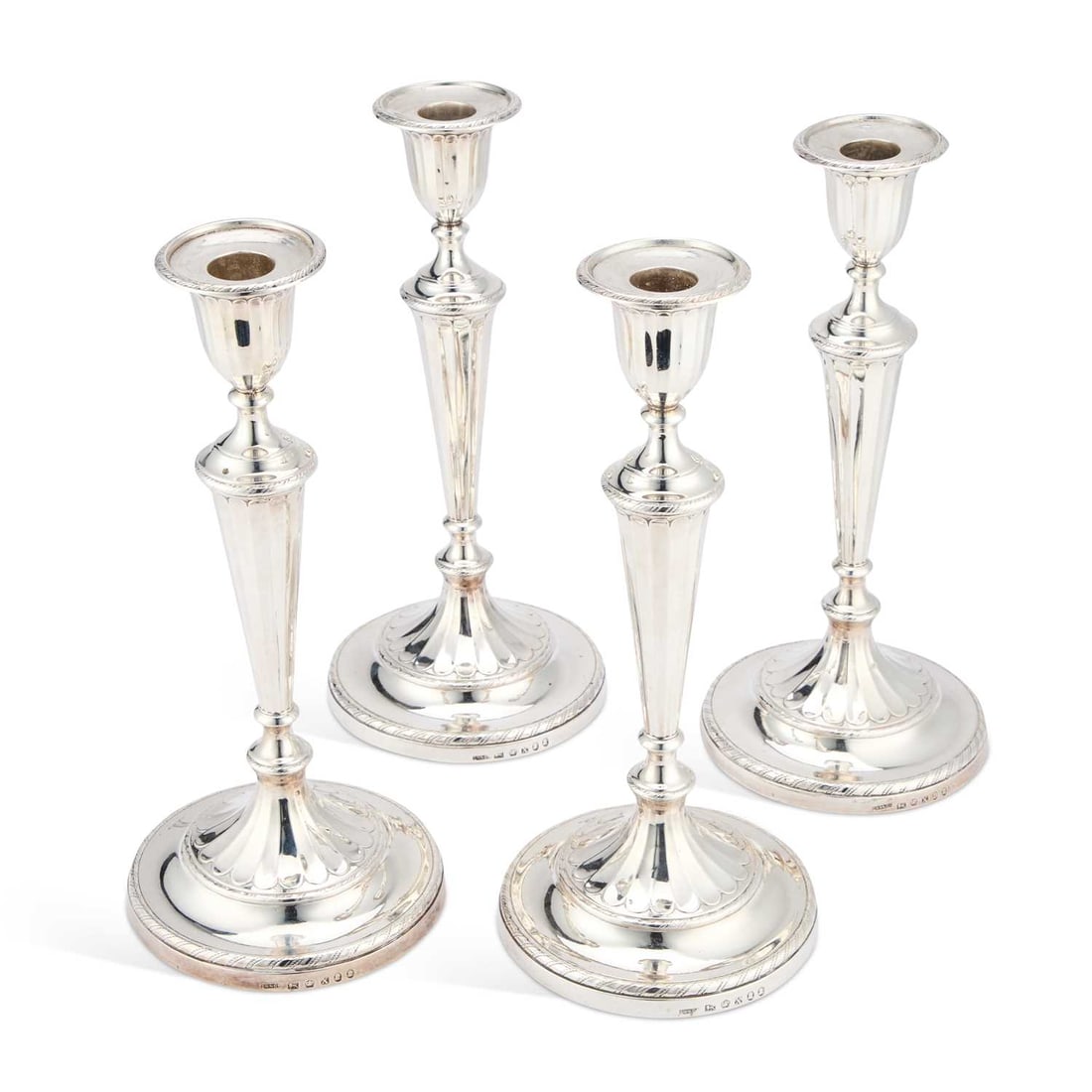 A PAIR OF GEORGE III NEOCLASSICAL SILVER CANDLESTICKS: A PAIR OF GEORGE III NEOCLASSICAL SILVER CANDLESTICKS by John Green, Roberts, Mosley & Co, Sheffield 1797, with double duty marks, each with a circular nozzle above a fluted urnular sconce, raised