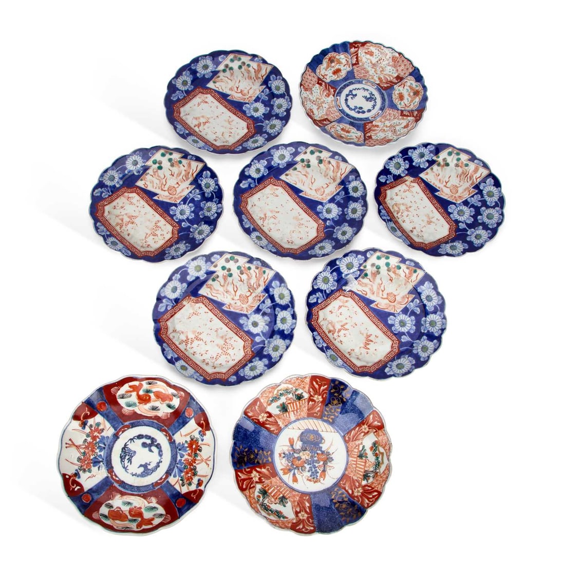 A COLLECTION OF NINE JAPANESE IMARI PLATES LATE 19TH CENTURY: A COLLECTION OF NINE JAPANESE IMARI PLATES LATE 19TH CENTURY each scalloped, painted in underglaze blue, iron-red and gilt. (9) 22cm diameter