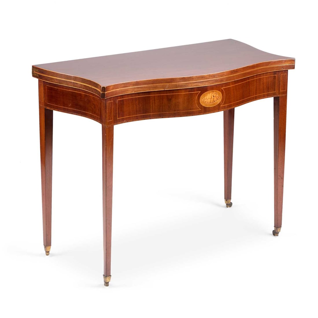 A GEORGE III STYLE INLAID MAHOGANY SERPENTINE FOLDOVER TEA TABLE CIRCA 1900: A GEORGE III STYLE INLAID MAHOGANY SERPENTINE FOLDOVER TEA TABLE CIRCA 1900 the frieze centred by an inlaid conch shell, raised on square-section tapering legs, terminating in brass caps and moving on