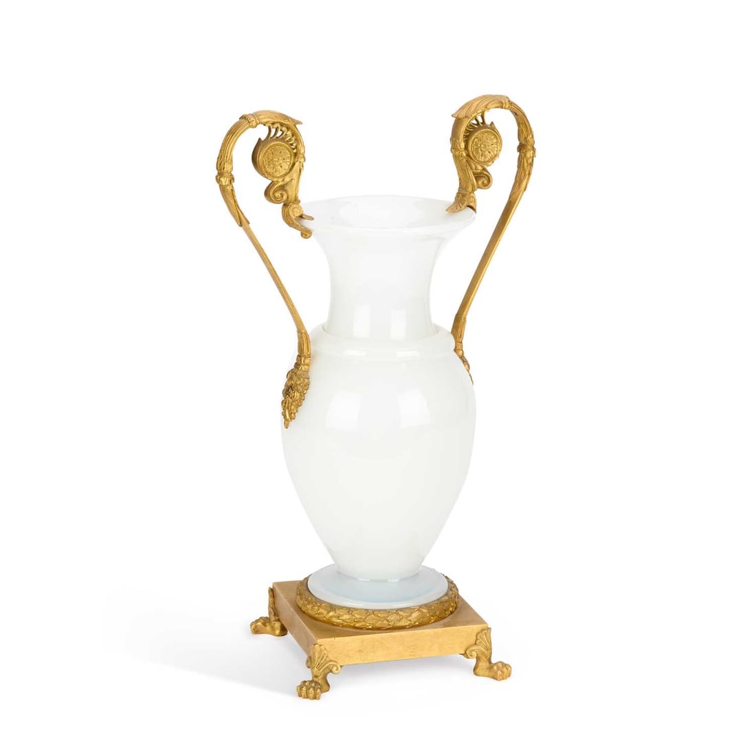 A FRENCH ORMOLU MOUNTED GLASS VASE CIRCA 1890: A FRENCH ORMOLU MOUNTED GLASS VASE CIRCA 1890 the baluster-shaped opaline glass vase, having gilt metal scroll handles and set within an ormolu laurel wreath, upon a square base, supported by lion paw