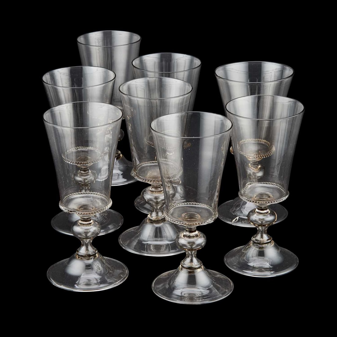 A SET OF EIGHT VENETIAN WINE GLASSES CIRCA 1900: A SET OF EIGHT VENETIAN WINE GLASSES CIRCA 1900 each with bucket bowl and knopped stem above a domed folded foot. (8) 19cm high but some variations