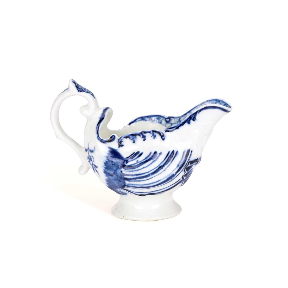 A DERBY PORCELAIN BUTTER BOAT CIRCA 1775: A DERBY PORCELAIN BUTTER BOAT CIRCA 1775 moulded with entwined dolphins beneath the spout, with shell moulding to the body, painted in underglaze blue with scrolls and flowers.10cm wide