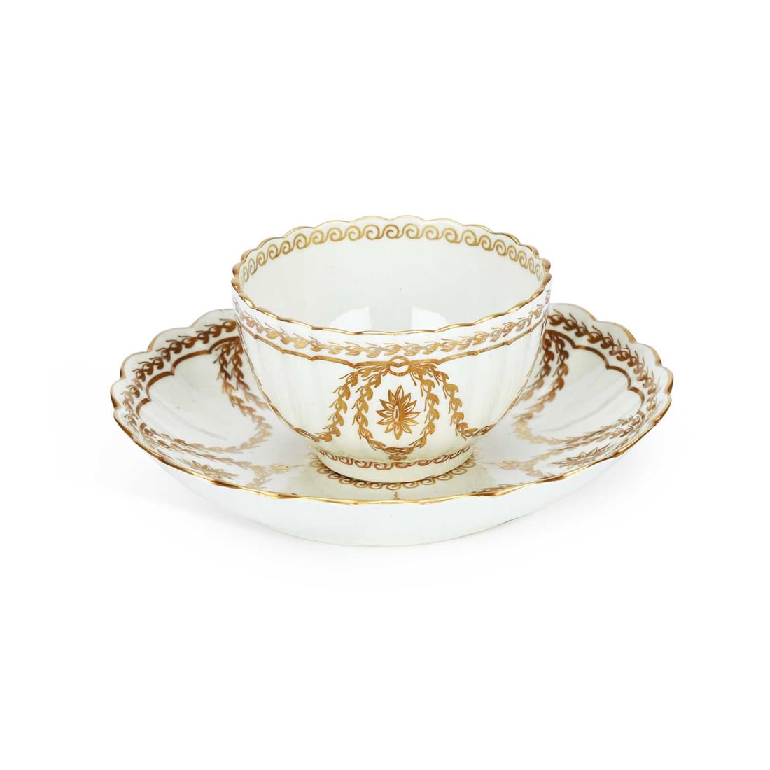 A WORCESTER PORCELAIN TEA BOWL AND SAUCER CIRCA 1785: A WORCESTER PORCELAIN TEA BOWL AND SAUCER CIRCA 1785 both decorated in the neo-classical style with gilt husks and paterae. (2) Saucer 14cm diameter Tiny chip to tea bowl footrim.