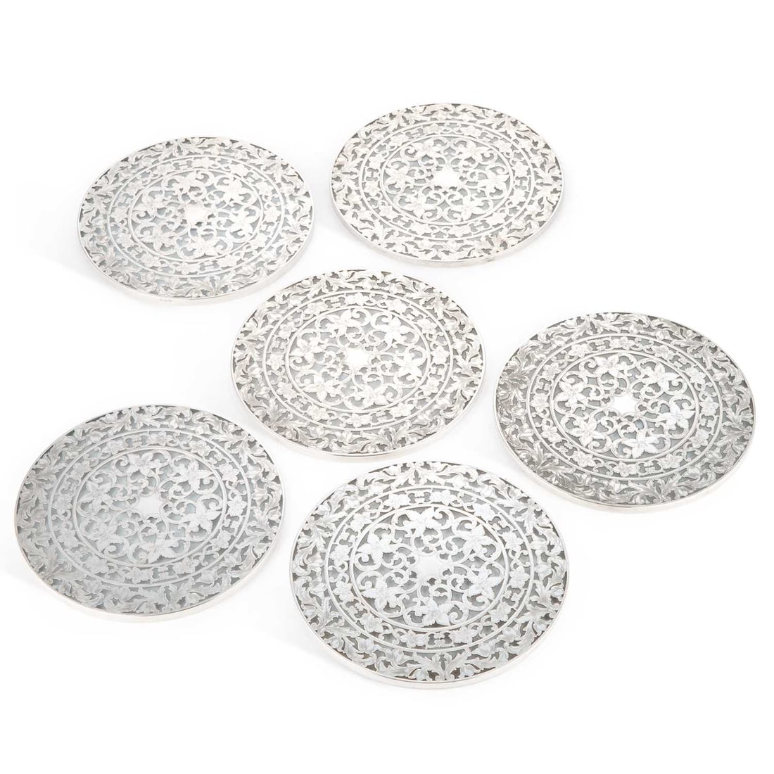 A SET OF SIX AMERICAN STERLING SILVER AND GLASS COASTERS 20TH CENTURY: A SET OF SIX AMERICAN STERLING SILVER AND GLASS COASTERS 20TH CENTURY by Webster Company, of circular form, the silver mounts pierced and engraved with a scrolling foliate pattern. (6) 20cm diameter