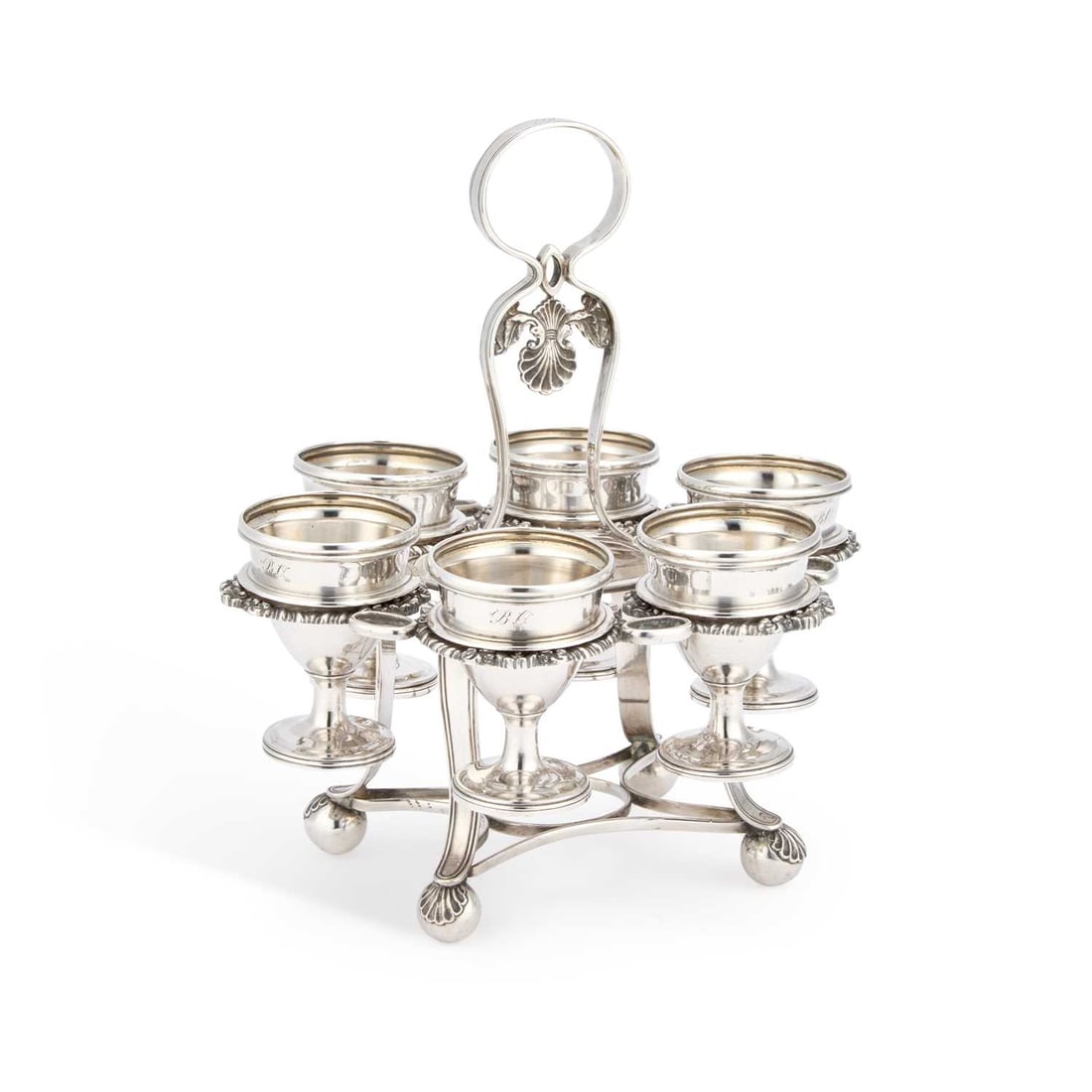 A CHINESE EXPORT SILVER EGG CRUET: A CHINESE EXPORT SILVER EGG CRUET Canton, c.1825, retailed by Wo Shing, the stand and egg cups with pseudo hallmarks and the retailer’s mark of a W, engraved with initials. 20cm high, 24.2 troy ounc