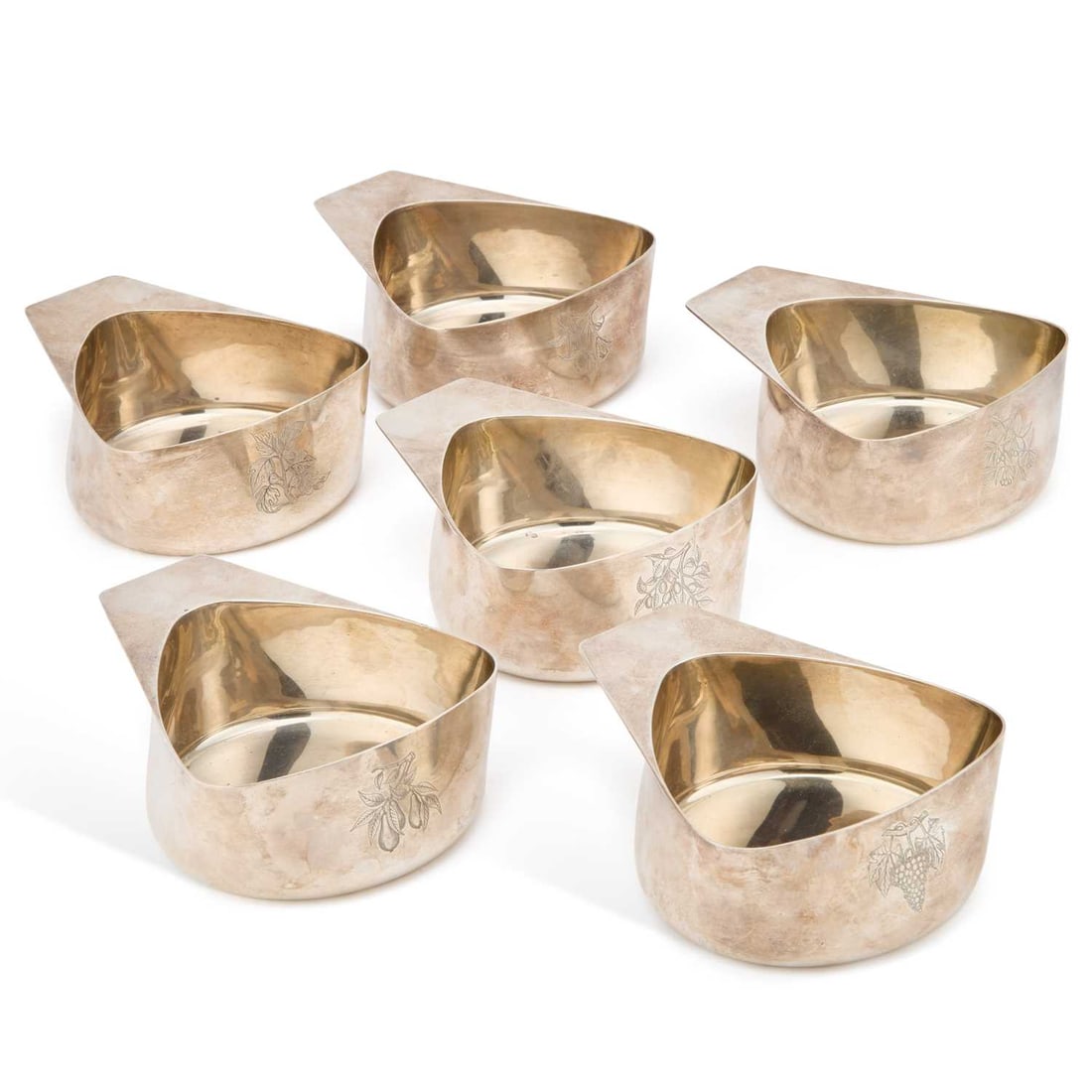A SET OF SIX MODERNIST SILVER BOWLS: A SET OF SIX MODERNIST SILVER BOWLS maker R W S, London 1964, each of stylised heart-shaped form with a projecting flat wing handle, each engraved with a differing botanical spray. (6) 14.5cm long, 63