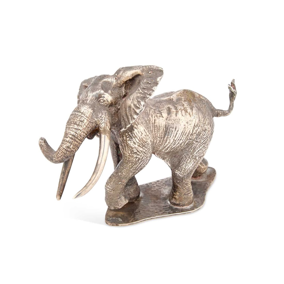 PATRICK MAVROS, A HEAVY CAST SILVER MODEL OF AN ELEPHANT: PATRICK MAVROS, A HEAVY CAST SILVER MODEL OF AN ELEPHANT modelled standing on a shaped base with trunk aloft to one side and tail raised. 10cm high, 33.3 troy ounces