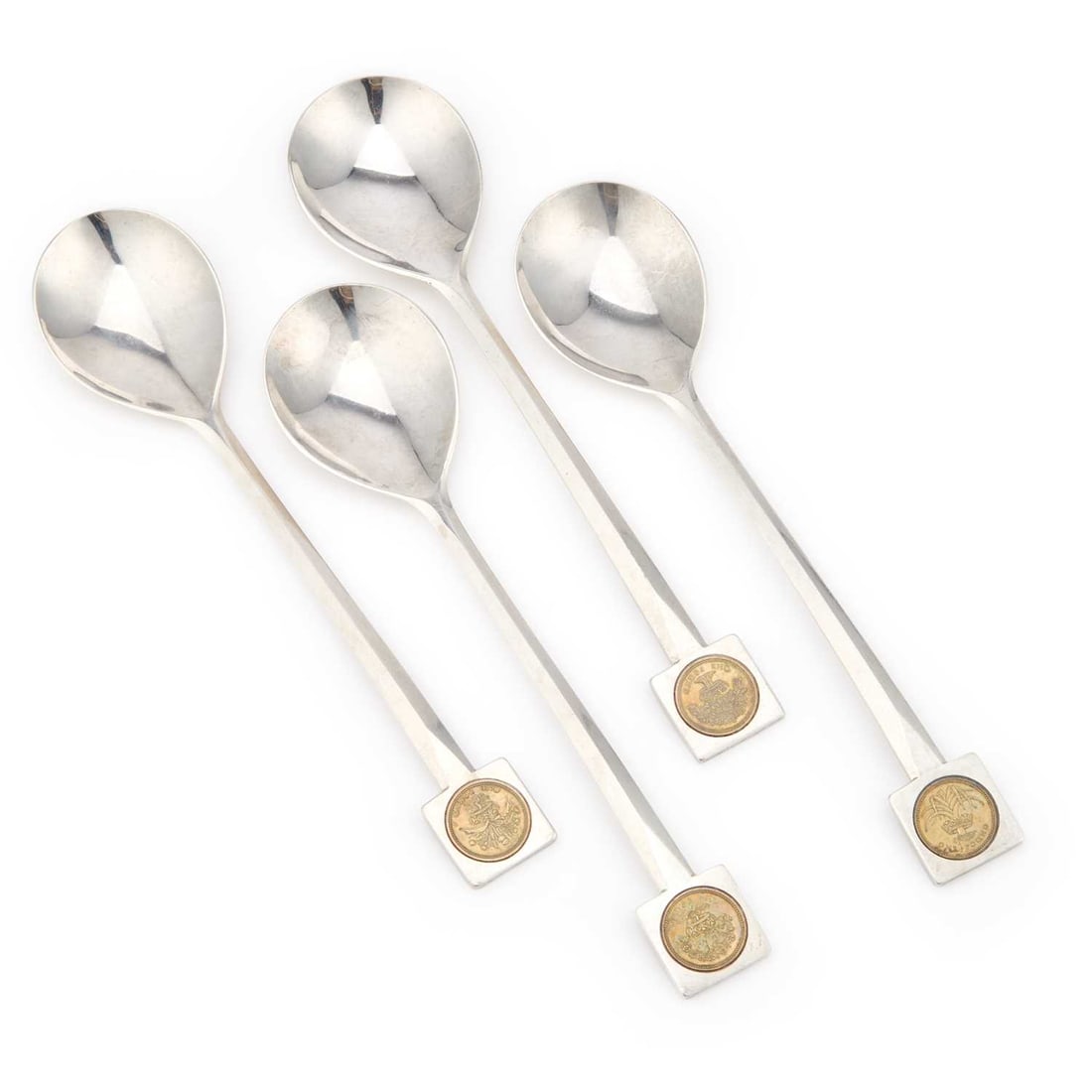 A SET OF FOUR MODERNIST SILVER SERVING SPOONS: A SET OF FOUR MODERNIST SILVER SERVING SPOONS by Leslie Gordon Durbin, London 1986, the square terminals inset with Elizabeth II £1 coins. (4) 23cm long, 11 troy ounces gross