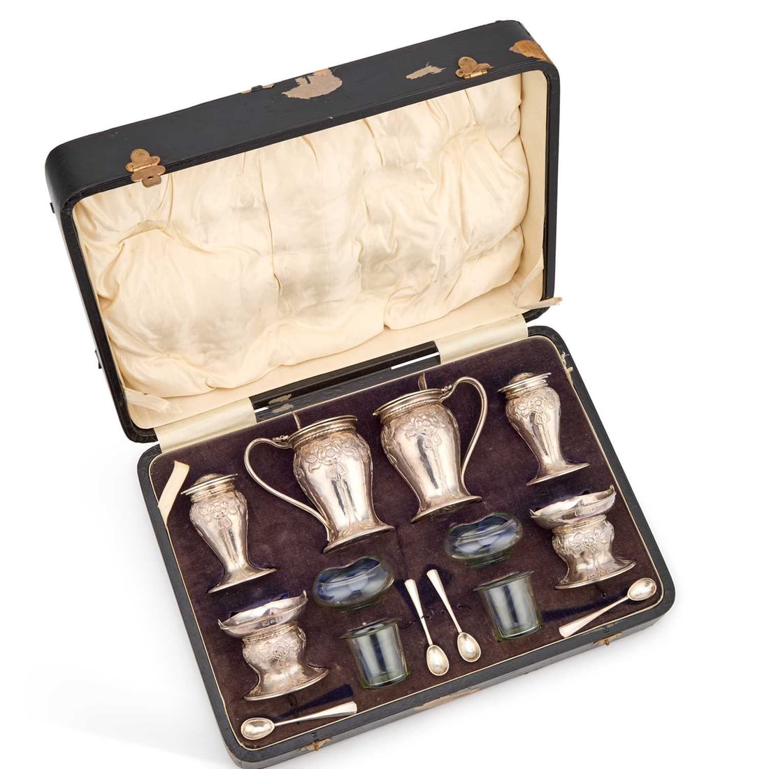 ALWYN CARR (1872-1940), AN ARTS AND CRAFTS SILVER CONDIMENT SET: ALWYN CARR (1872-1940), AN ARTS AND CRAFTS SILVER CONDIMENT SET London 1925, comprising a pair of lidded mustard pots with green glass liners, a pair of pepper pots, a pair of salts with green glass l