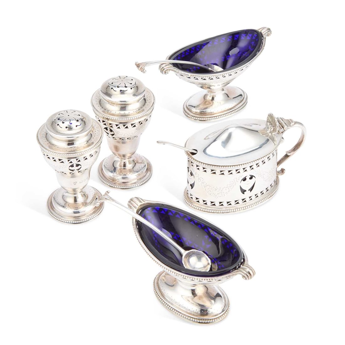AN EDWARDIAN SILVER CRUET SET: AN EDWARDIAN SILVER CRUET SET by Harrods Ltd, London 1920 and 1923, comprising a pair of salts, a pair of pepperettes and a mustard pot, each pierced with urns and scrolling borders and engraved with 