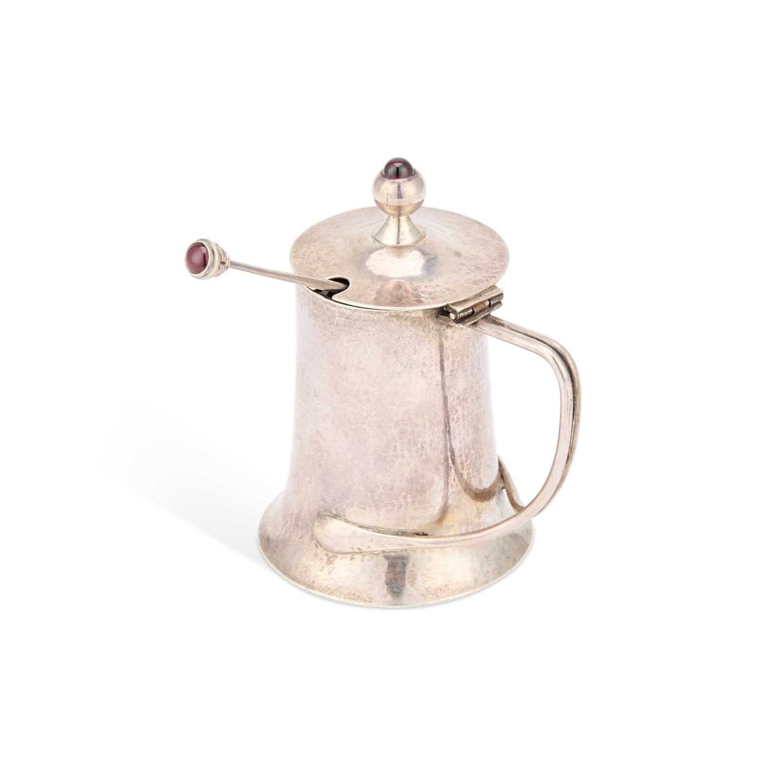 CHARLES ROBERT ASHBEE (1863-1942) AN ARTS AND CRAFTS SILVER MUSTARD POT: CHARLES ROBERT ASHBEE (1863-1942) AN ARTS AND CRAFTS SILVER MUSTARD POT by Guild of Handicraft, London 1902, the hinged lid with a globular finial inset with a red cabochon, the spreading hammered bod