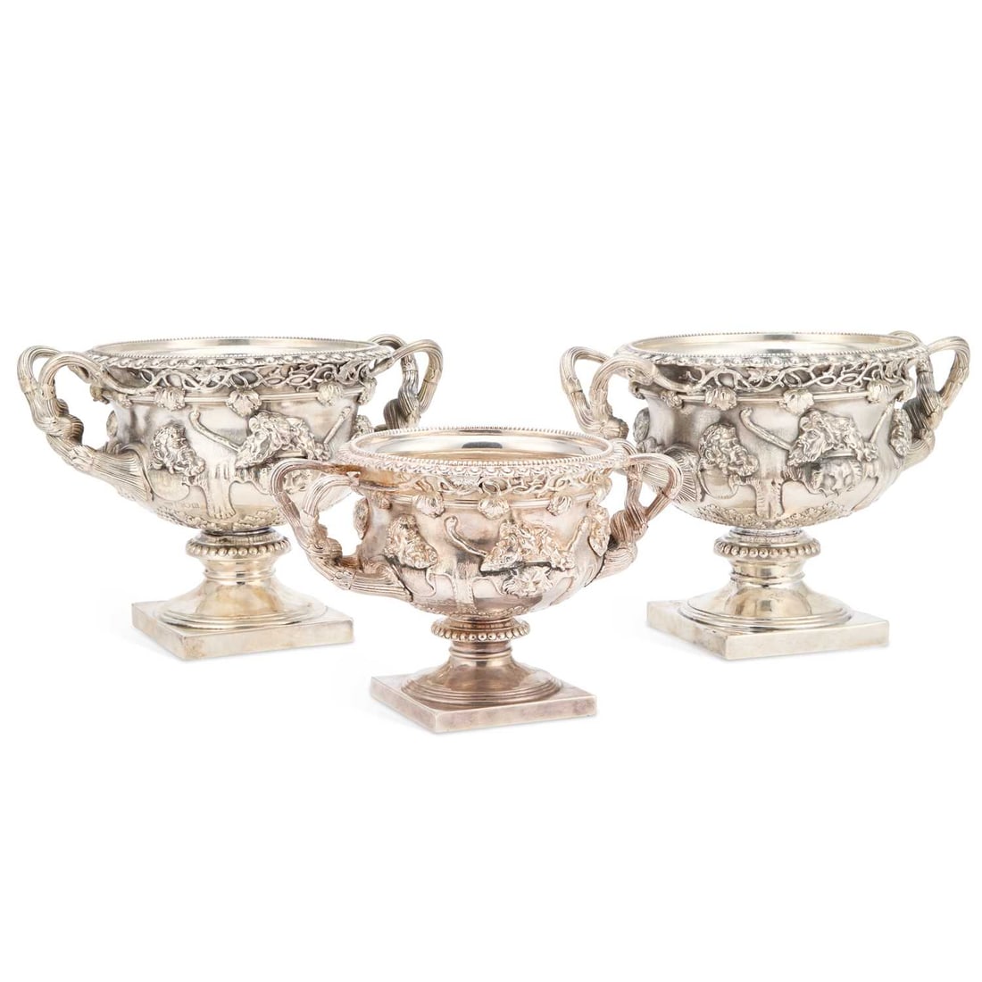 A PAIR OF GEORGE V SILVER WARWICK VASES: A PAIR OF GEORGE V SILVER WARWICK VASES by Goldsmiths and Silversmiths Co. Ltd, London 1910, each of typical form, on a square base, the sides cast with bacchic masks and thyrsi, all on a lion pelt-ca