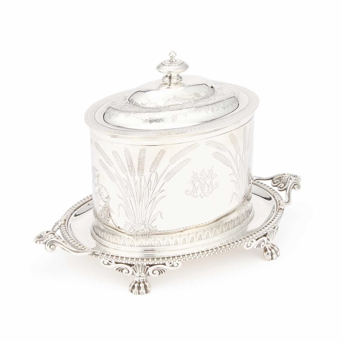 A FINE VICTORIAN SILVER BISCUIT BOX: A FINE VICTORIAN SILVER BISCUIT BOX by Walter & John Barnard, London 1884, of oval form, the barrel with a domed hinged cover, engraved with wheat sheaves and a monogram, the integral base with tw