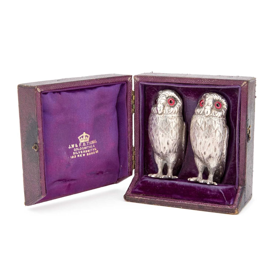A PAIR OF VICTORIAN SILVER NOVELTY PEPPER POTS: A PAIR OF VICTORIAN SILVER NOVELTY PEPPER POTS by Edward Charles Brown, London 1867, each modelled as an owl, with inset glass eyes, in the original fitted case. (2) 7.6cm high, 2.8 troy ounces gross