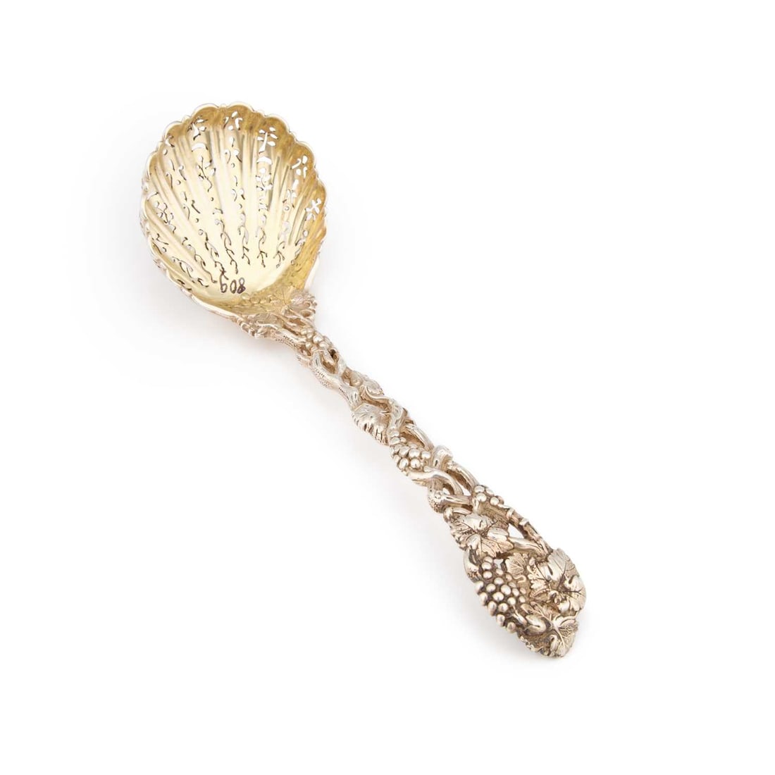 A VICTORIAN SILVER SIFTING LADLE: A VICTORIAN SILVER SIFTING LADLE lacking maker's mark, London 1852, with a cast grape and vine pattern handle and shell-form bowl with a gilt interior, engraved with a crest and motto. 15.7cm long,