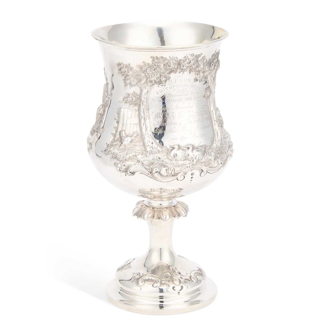 A LARGE VICTORIAN SILVER TROPHY CUP: A LARGE VICTORIAN SILVER TROPHY CUP by Henry Holland (of Holland, Aldwinckle & Slater), London 1868, the oversized goblet chased with a vignette of cattle, sheep and pigs in a pastoral landscape, 
