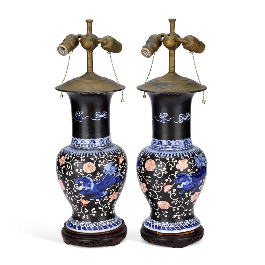 A PAIR OF CHINESE PORCELAIN LAMPS 19TH CENTURY: A PAIR OF CHINESE PORCELAIN LAMPS 19TH CENTURY the baluster-shaped vases painted in underglaze blue with qilin amongst foliage, on a black ground, set upon hardwood stands. (2) 61cm high