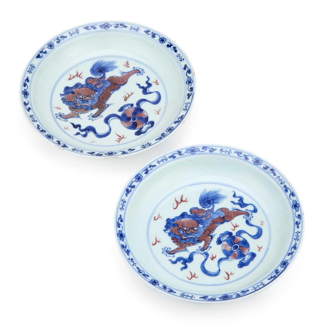 A PAIR OF CHINESE PORCELAIN DISHES: A PAIR OF CHINESE PORCELAIN DISHES both hand painted with a qilin chasing a brocade ball in underglaze blue and copper red, within a concentric circle, the rims with a floral border, having lingzhi de