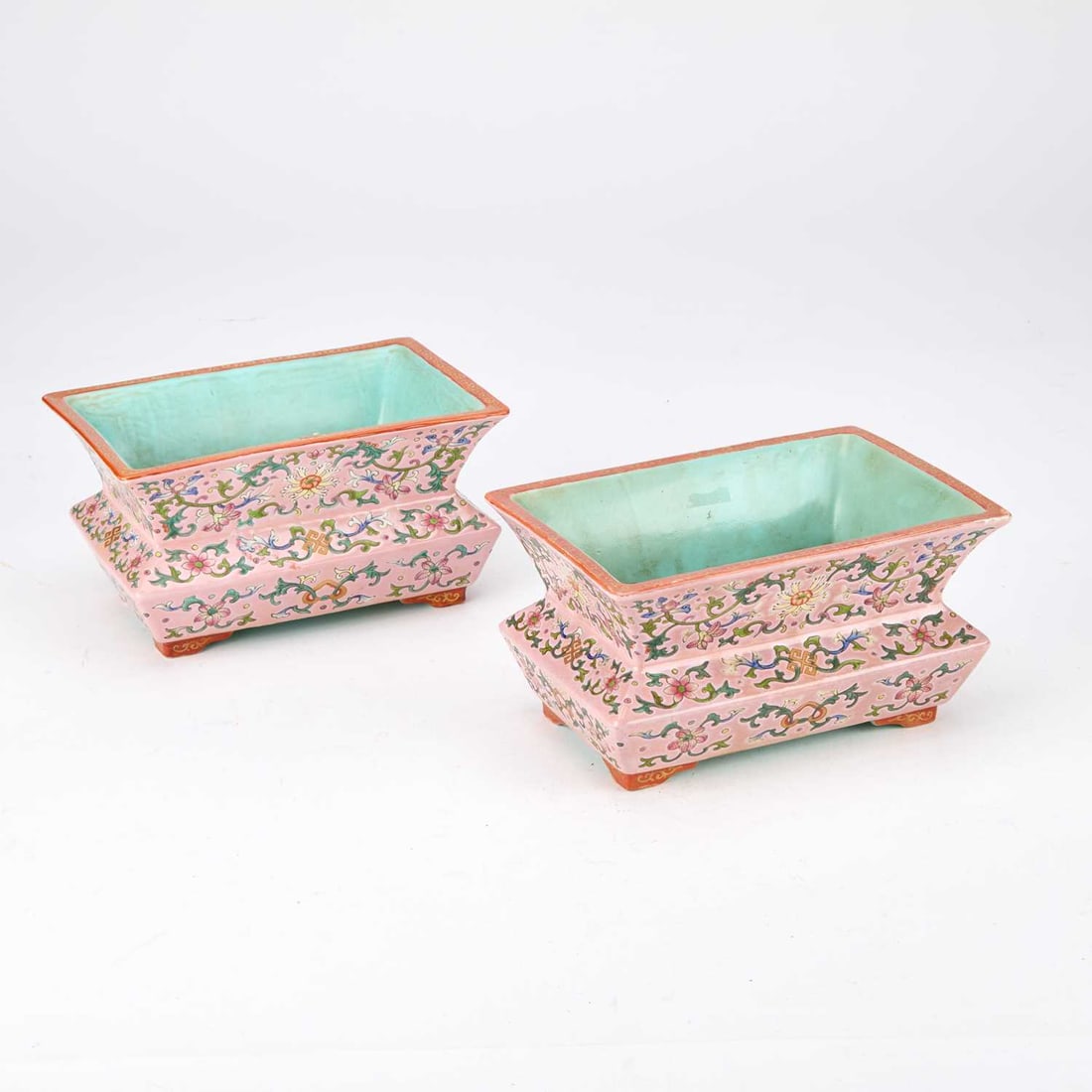 A PAIR OF CHINESE FAMILLE ROSE PLANTERS: A PAIR OF CHINESE FAMILLE ROSE PLANTERS rectangular form, enamelled in famille rose enamel with stylised lotus scroll and Buddhistic emblems, on a pink ground, the interior turquoise glazed, standing 