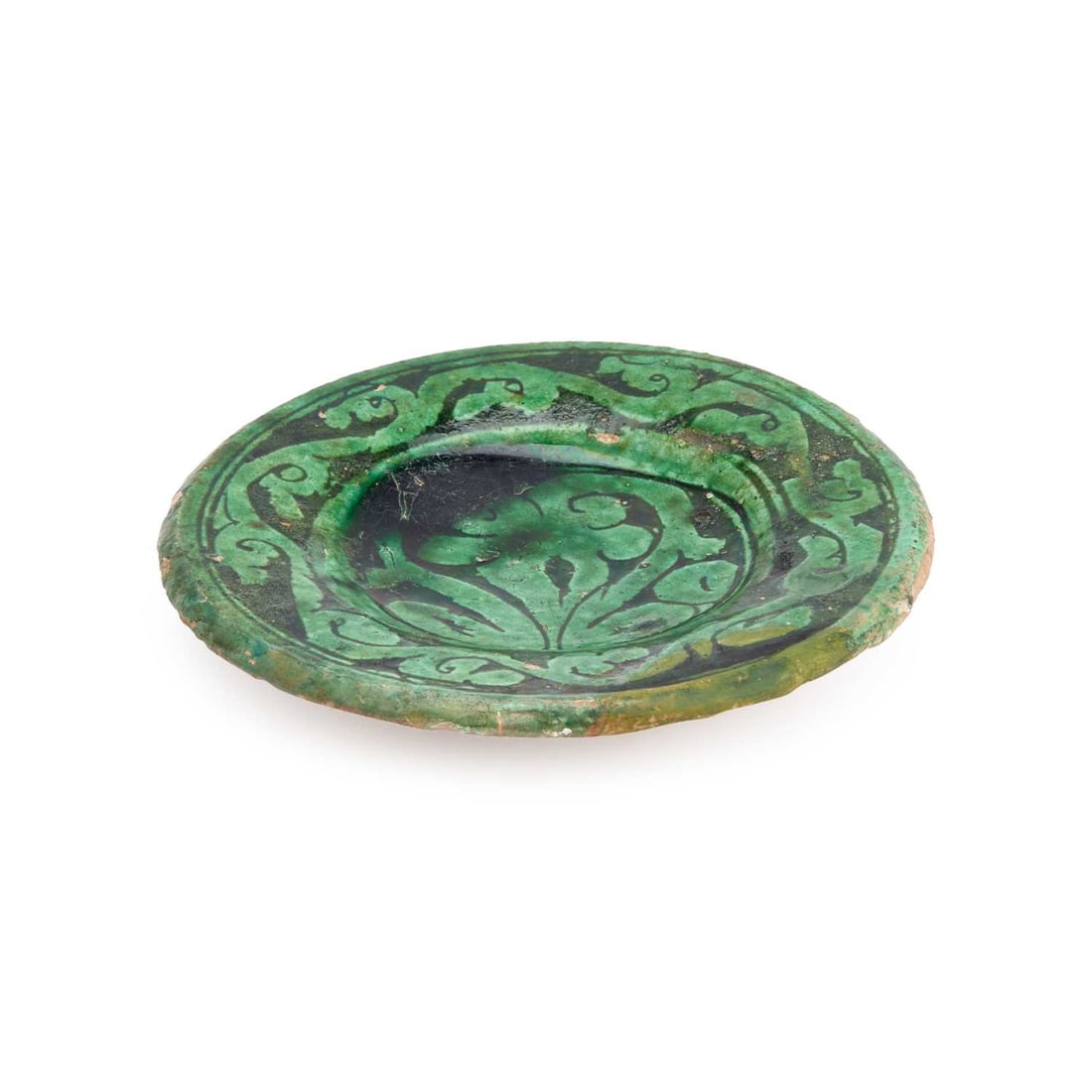 A PERSIAN SELJUK STYLE DISH CIRCA 1150: A PERSIAN SELJUK STYLE DISH CIRCA 1150 the small earthenware dish decorated in green glaze with scrolling foliage. 14.5cm diameter