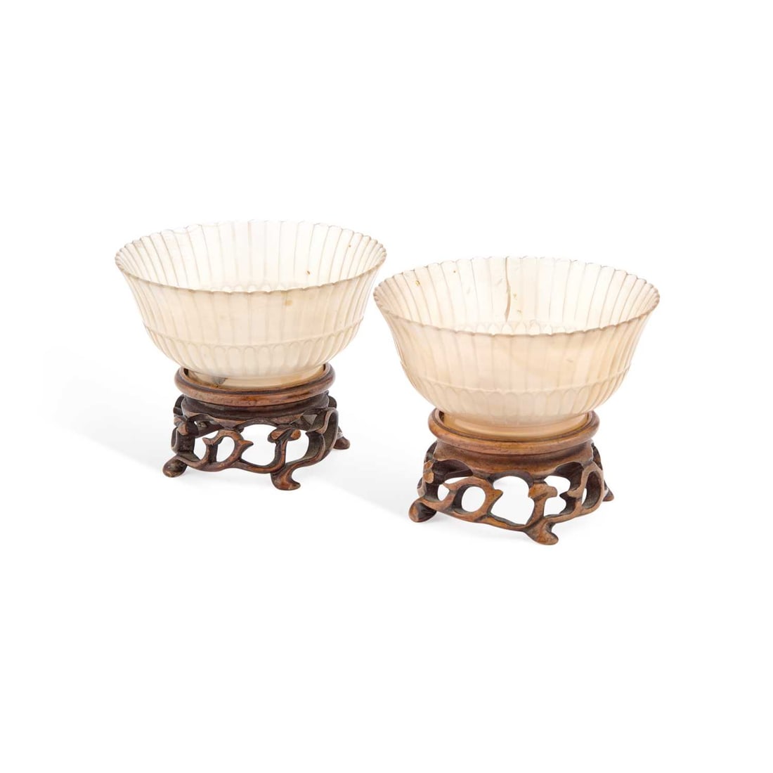 A PAIR OF CHINESE MUGHAL STYLE AGATE BOWLS QING DYNASTY: A PAIR OF CHINESE MUGHAL STYLE AGATE BOWLS QING DYNASTY the small chrysanthemum form bowls finely fluted and set upon circular footrims, having wood stands, carved with lingzhi scroll feet. (4) 3cm
