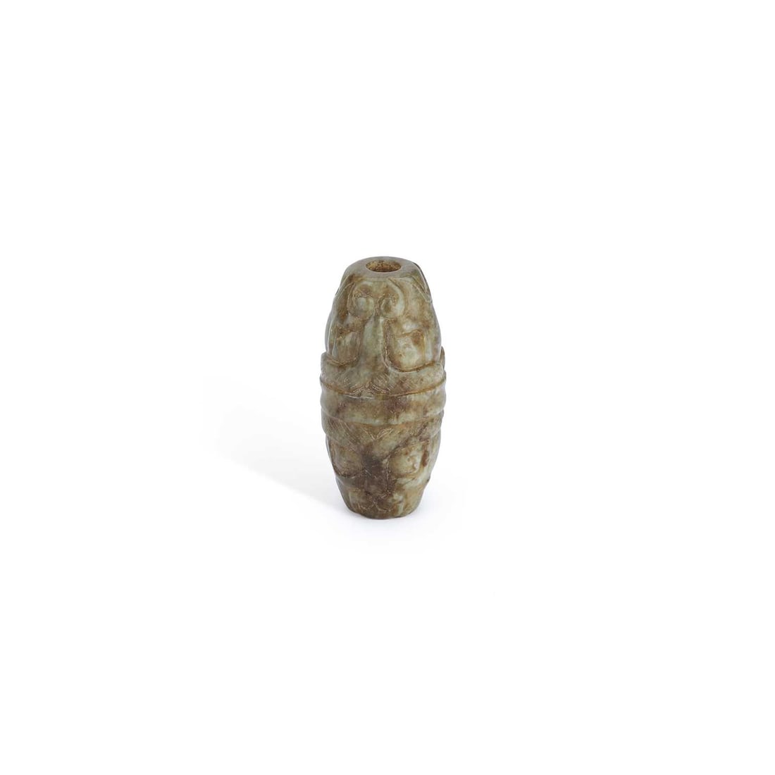 A CHINESE JADE BEAD OR PENDANT: A CHINESE JADE BEAD OR PENDANT carved in relief with stylised taotie masks and archaistic scroll motifs, drilled longitudinally, the mottled grey-green stone with darker inclusions. 4cm long
