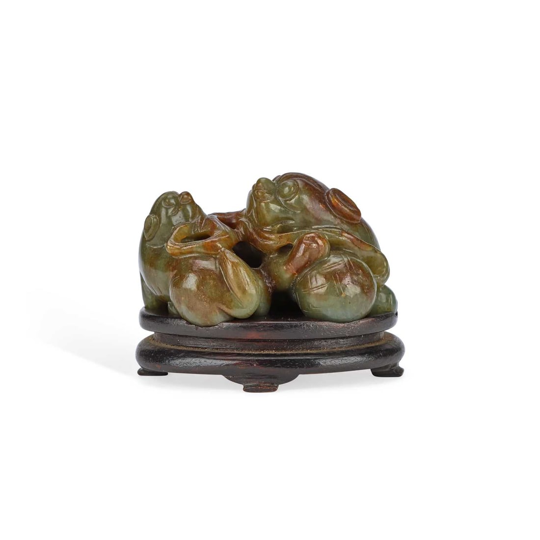 A CHINESE JADE CARVING OF A BUDDHIST LION AND PUPPY: A CHINESE JADE CARVING OF A BUDDHIST LION AND PUPPY carved in green and russet jade as a recumbent Buddhist lion beside its playful cub amidst trailing foliage and a brocade ball, raised on a
