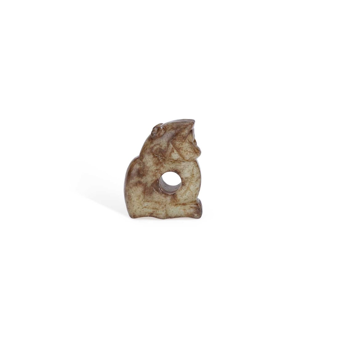 A CHINESE MOTTLED GREY JADE CARVING OF A FROG: A CHINESE MOTTLED GREY JADE CARVING OF A FROG carved in a crouching posture with bulging eyes and folded limbs, pierced through the body with a large circular aperture, the stone with dark brown and b