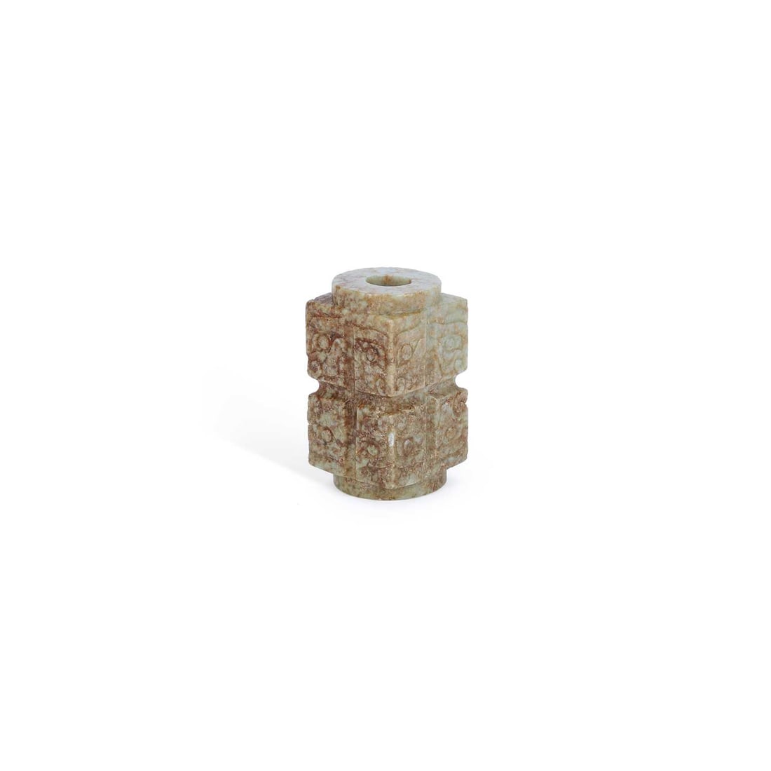 A CHINESE JADE CONG: A CHINESE JADE CONG carved in archaistic style with stylised taotie masks to each side, the cylindrical aperture running through the centre, the stone of pale celadon tone with russet inclusions. 4cm 
