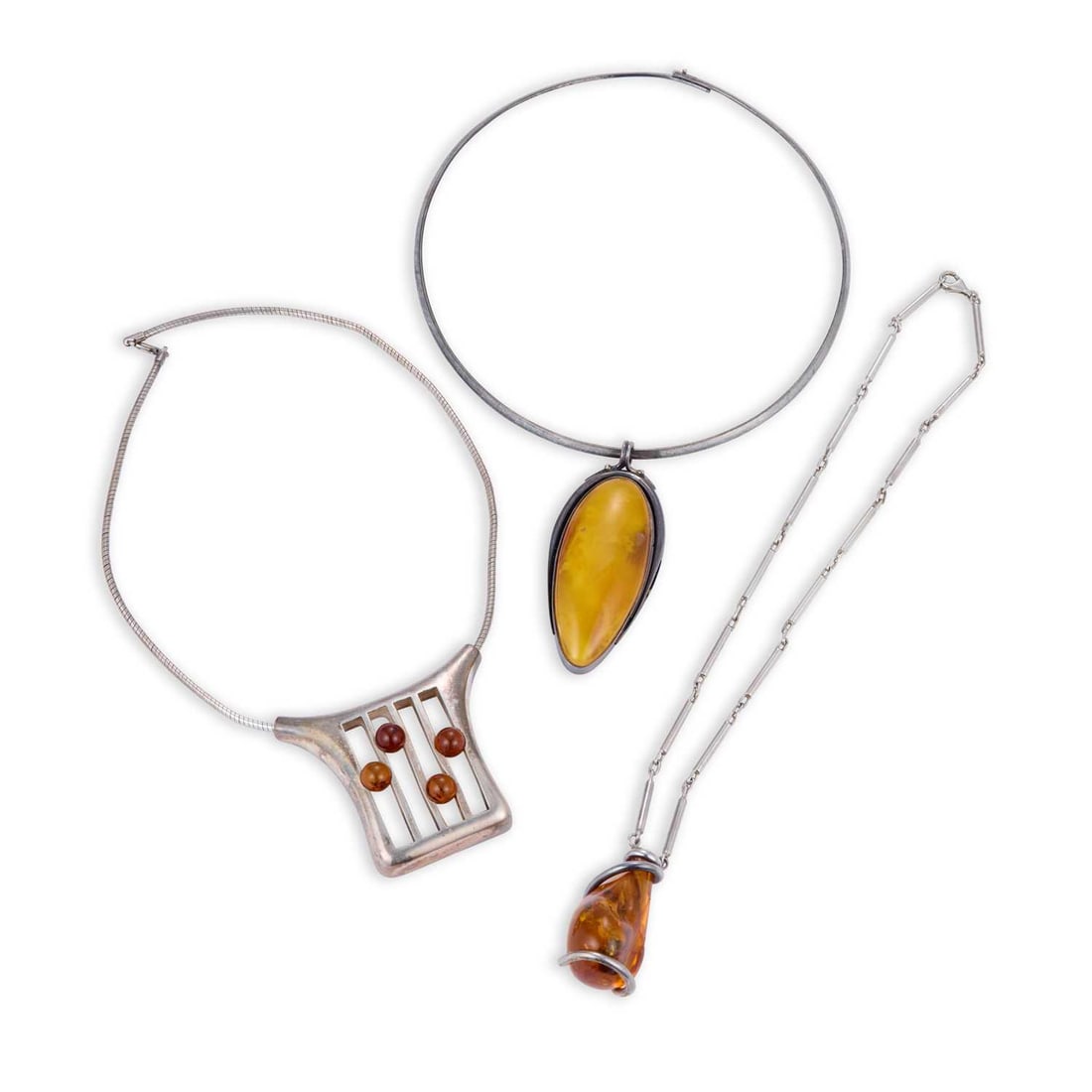 THREE SILVER AND AMBER PENDANT NECKLACES: THREE SILVER AND AMBER PENDANT NECKLACES including an elongated oval pendant, with Polish hallmarks, 925 Standard, Gdansk; etc. (3) First pendant 7.2cm high, 121.6 grams gross