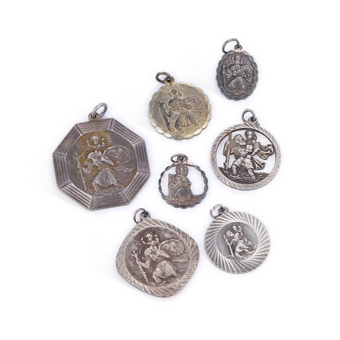 A GROUP OF SILVER ST CHRISTOPHER PENDANTS: A GROUP OF SILVER ST CHRISTOPHER PENDANTS including a large octagonal example by Georg Jensen; etc. (7) Largest 3.5cm wide, 57.9 grams gross