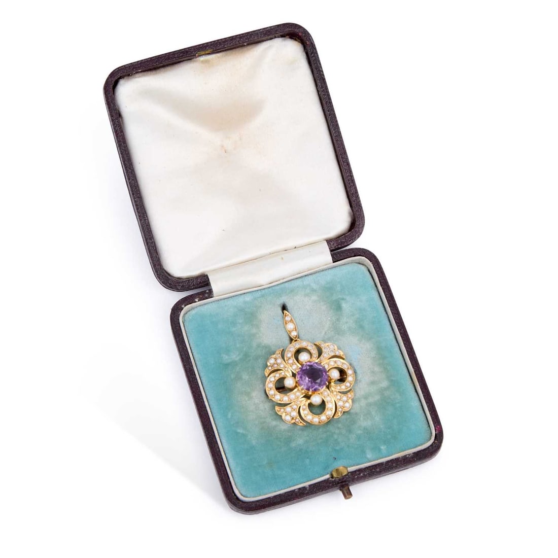 AN EDWARDIAN AMETHYST AND SEED PEARL BROOCH PENDANT: AN EDWARDIAN AMETHYST AND SEED PEARL BROOCH PENDANT a round-cut amethyst within a seed pearl set scroll frame, with a removeable bail, unmarked, in a fitted case. 3.5cm long, 7 grams Some wear to the 