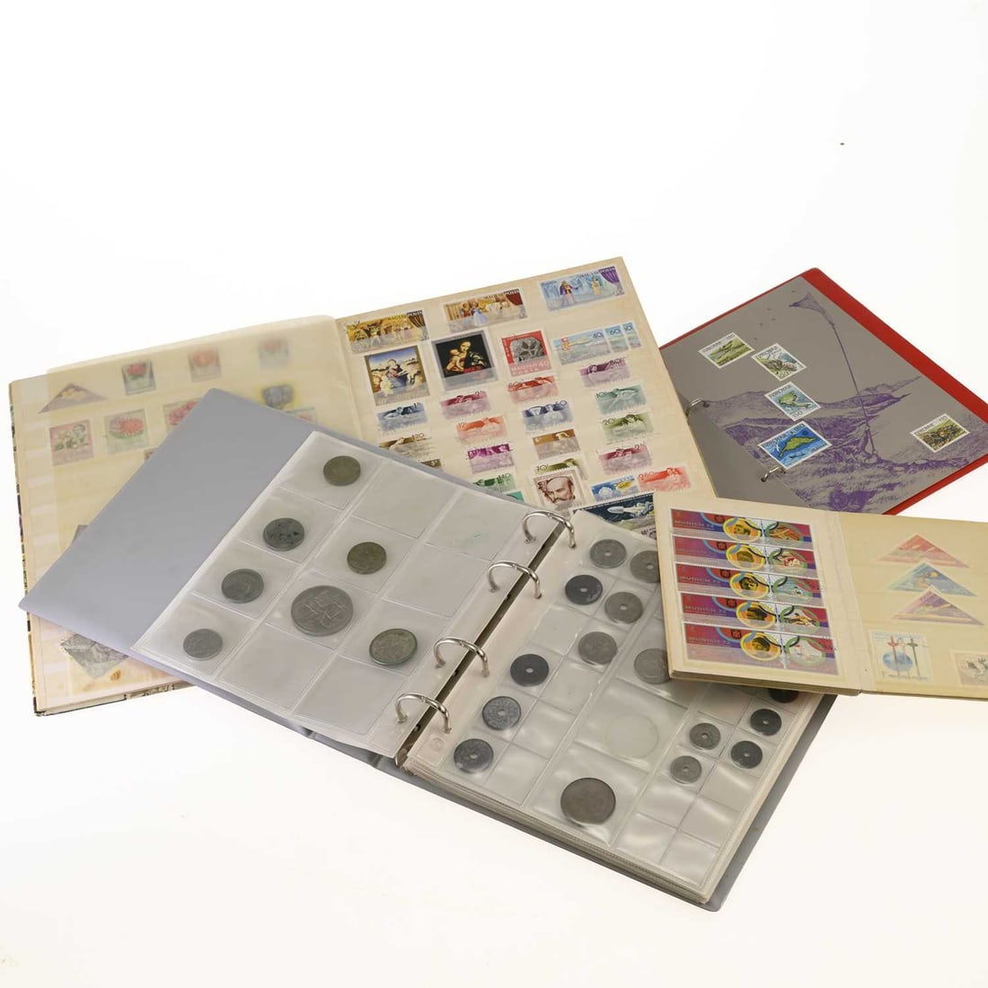 A COLLECTION OF WORLD STAMPS AND COINS: A COLLECTION OF WORLD STAMPS AND COINS contained in four albums, including mint and used stamps from Great Britain, the Commonwealth, Europe, Asia and South America; together with assorted 20th