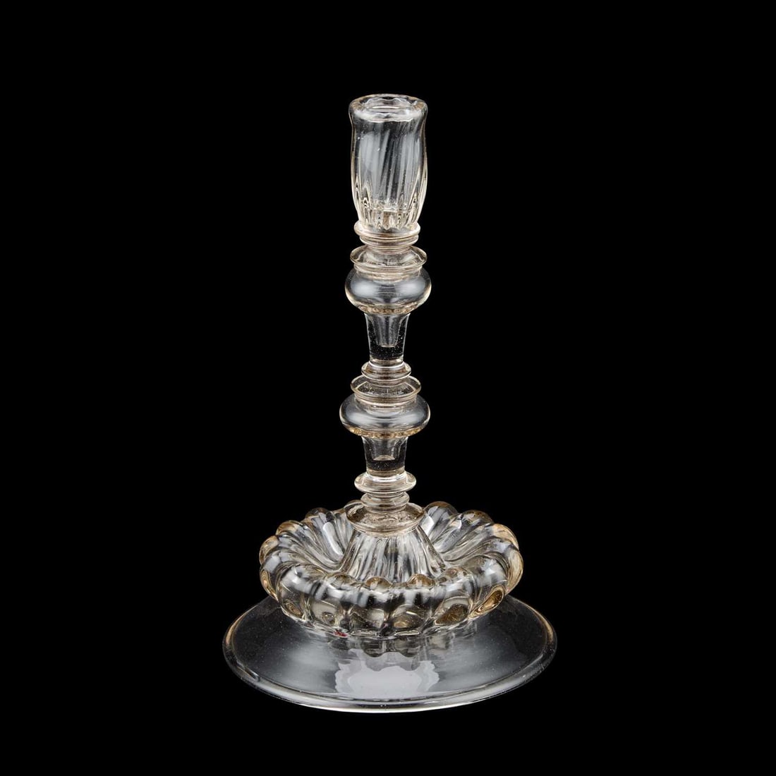 A MOULDED STEM CANDLESTICK 18TH CENTURY: A MOULDED STEM CANDLESTICK 18TH CENTURY with a knopped stem and domed base. 22cm high Good condition commensuate with age, no visible damage. We think it could be Venetian, but possibly a 19th