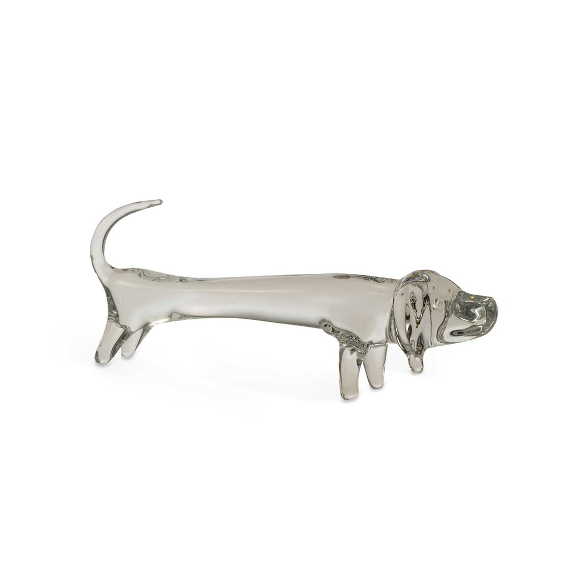 A DAUM CLEAR GLASS MODEL OF A DACHSHUND: A DAUM CLEAR GLASS MODEL OF A DACHSHUND naturalistically modelled standing with a raised tail, signed Daum France. 40cm long