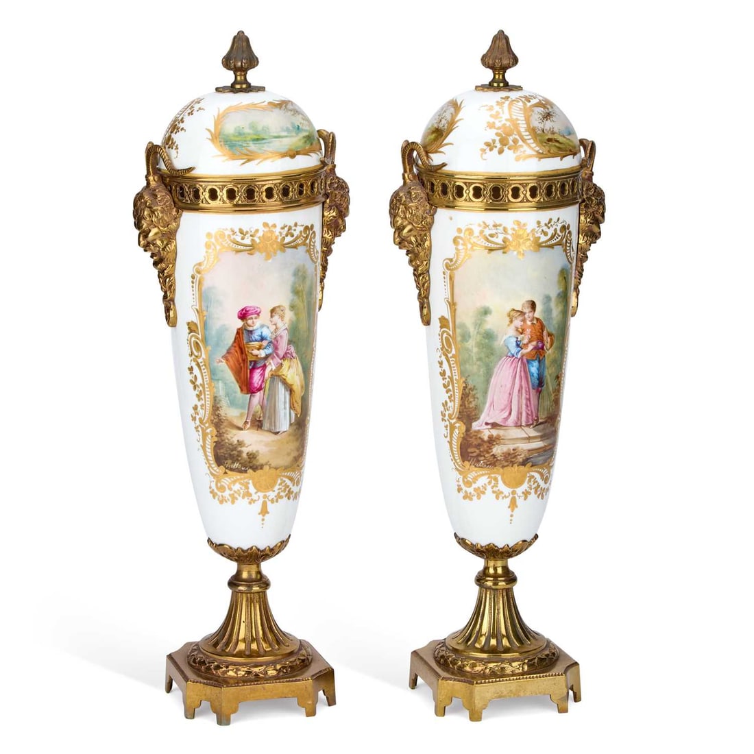A PAIR OF SÈVRES STYLE PORCELAIN VASES CIRCA 1890: A PAIR OF SÈVRES STYLE PORCELAIN VASES CIRCA 1890 painted with panels of lovers and rural scenes, on a white ground, the domed covers similarly decorated, having gilt-metal mask handles and set upon