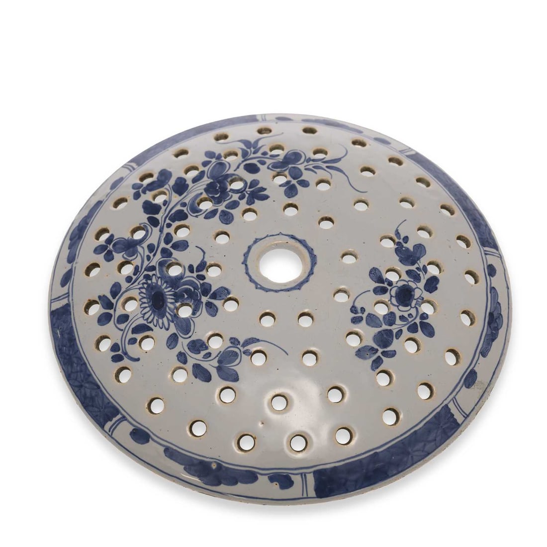 A LONDON DELFT DRAINER CIRCA 1760: A LONDON DELFT DRAINER CIRCA 1760 pierced and painted with floral sprigs in underglaze blue. 25cm diameter