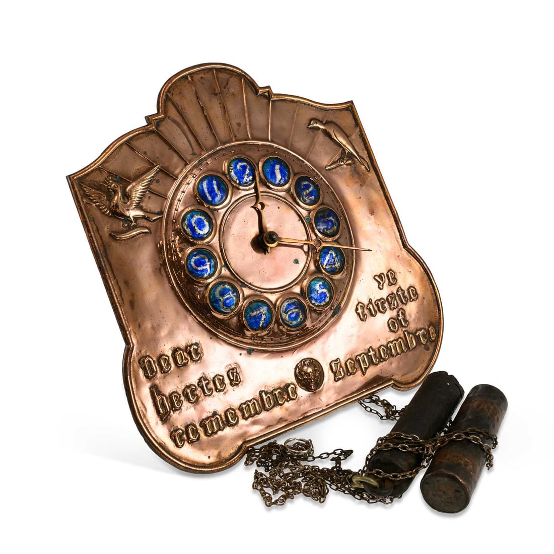AN ARTS AND CRAFTS COPPER WALL CLOCK: AN ARTS AND CRAFTS COPPER WALL CLOCK the shaped repoussé case decorated with birds flanking the blue enamel numeral chapter ring, with a Gothic-style inscription below, the weight-driven movement str