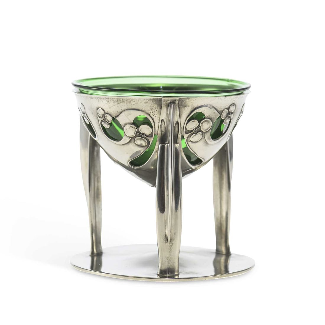 ARCHIBALD KNOX (1864-1933) FOR LIBERTY & CO A TUDRIC PEWTER COUPE: ARCHIBALD KNOX (1864-1933) FOR LIBERTY & CO A TUDRIC PEWTER COUPE the bowl pierced and cast with stylised foliage, raised on three finned supports to a circular base, with a green glass liner, no. 027