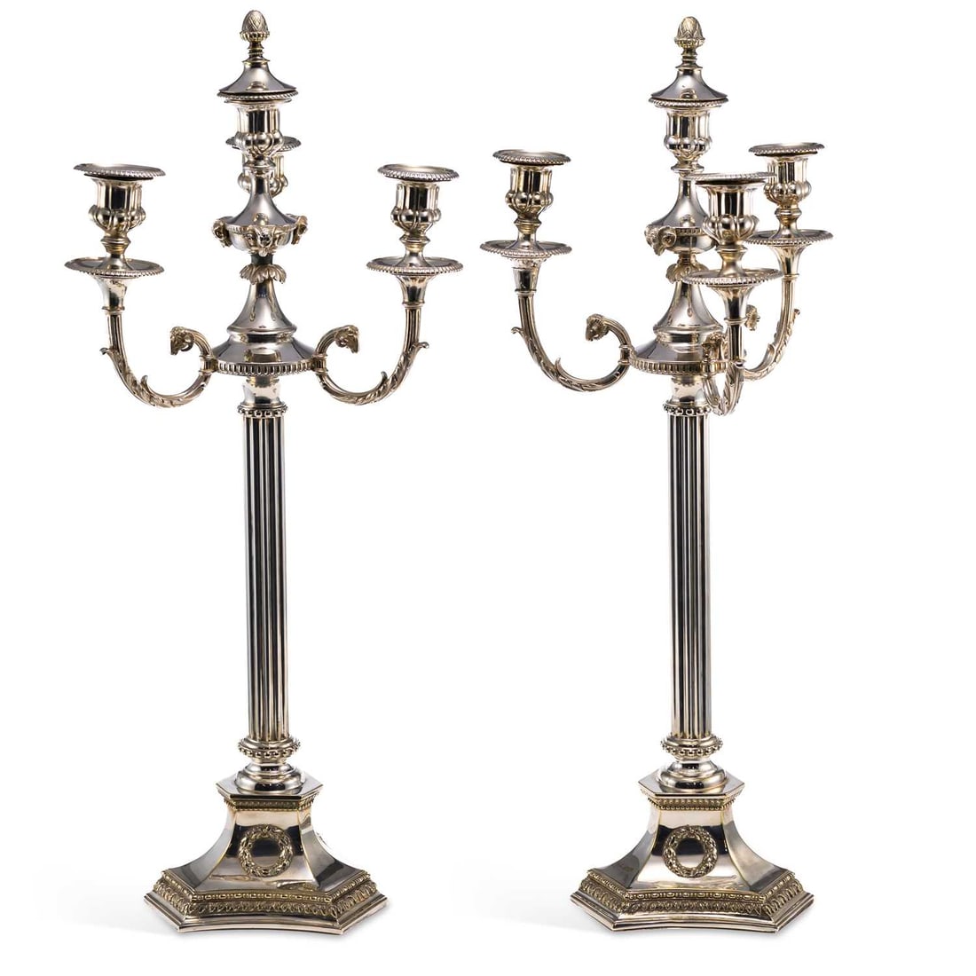A PAIR OF SILVER-PLATED THREE-BRANCH CANDELABRA: A PAIR OF SILVER-PLATED THREE-BRANCH CANDELABRA Neoclassical style, each with an acorn finial, ram's head and scroll branches, over doric columns on a shaped base. (2) 70cm high