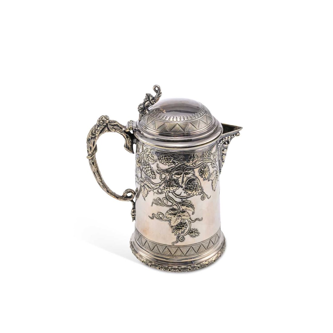 A VICTORIAN SILVER-PLATED LIDDED JUG: A VICTORIAN SILVER-PLATED LIDDED JUG of tapering cylindrical form with a hinged domed cover, chased with scrolling fruiting vine. 21cm high