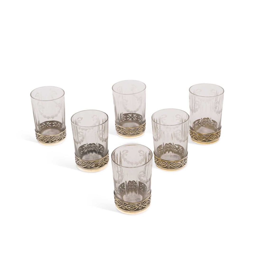 A SET OF SIX SILVER AND CUT GLASS TODDY CUPS: A SET OF SIX SILVER AND CUT GLASS TODDY CUPS c.1900, makers mark LT, each with a pierced silver foot rim, the cut-glass cups engraved with ribbons and swags. (6) 5.2cm high