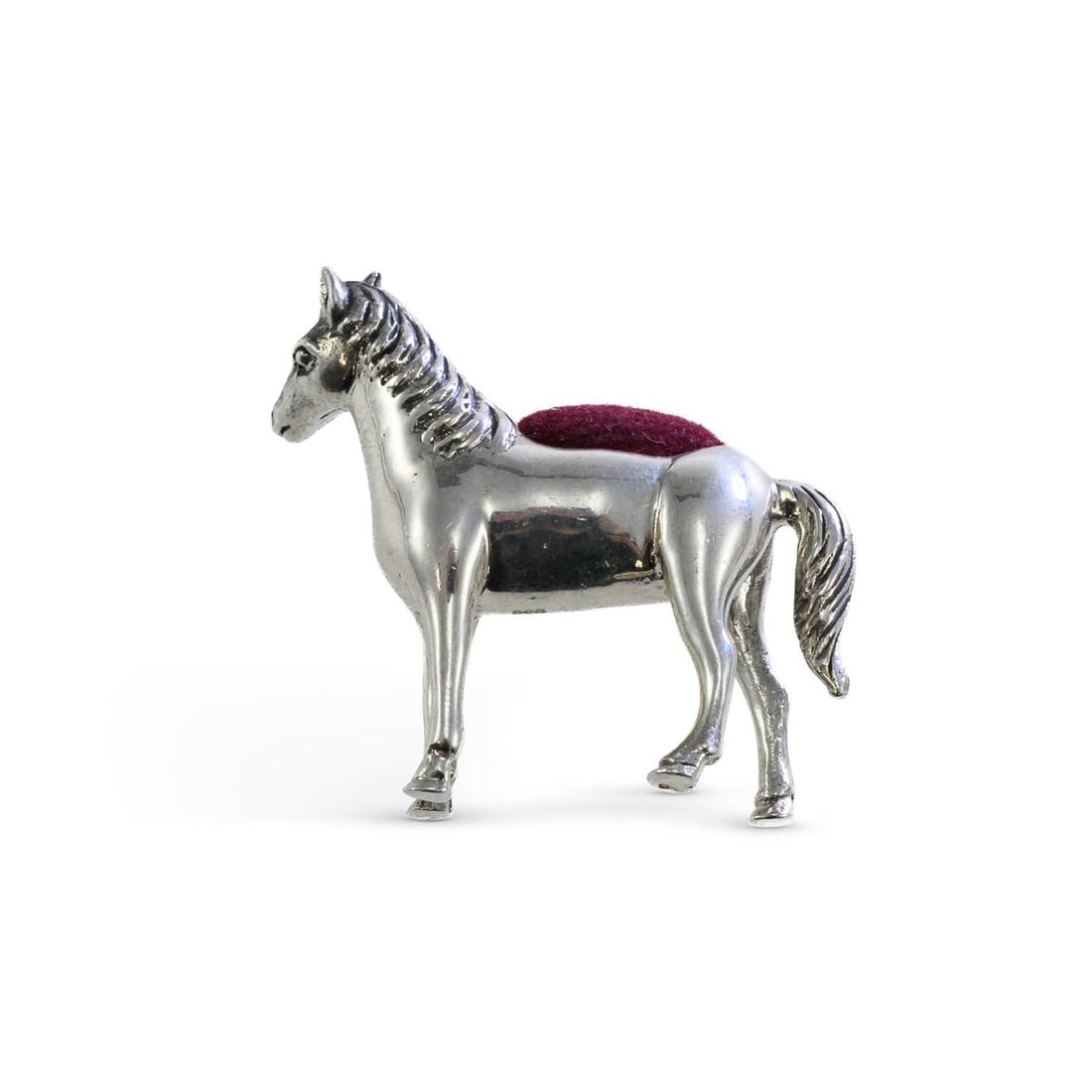A CONTINENTAL NOVELTY SILVER PIN CUSHION IN THE FORM OF A HORSE: A CONTINENTAL NOVELTY SILVER PIN CUSHION IN THE FORM OF A HORSE 20th century, marked 925, modelled standing, with a burgundy velvet cushion. 3.5cm high